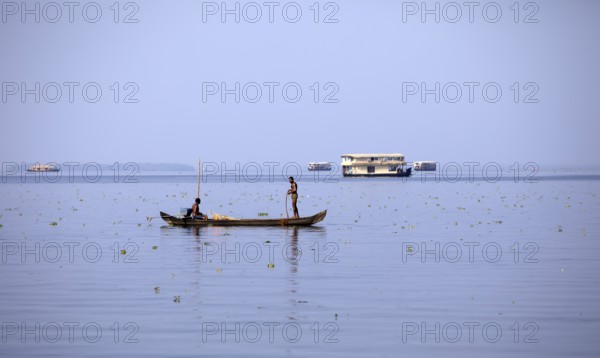 Fisherman on a small boat on the Vembanad Lake, canal system of the backwaters, Kerala, India, Asia