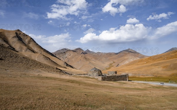 Historic caravanserai Tash Rabat from the 15th century, with yellow hills, Atbashy district in the Naryn region, Kyrgyzstan, Asia