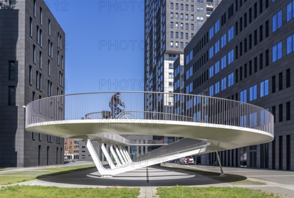 The Parkbruk, cycle and pedestrian bridge in the city centre of Antwerp, crosses a multi-lane city centre road with tram lines and thus connects two lively city districts Kop Spoor Noord and Eilandje, 140 metres of curved ramp on the western side for driving up and down, walking, Belgium, Europe