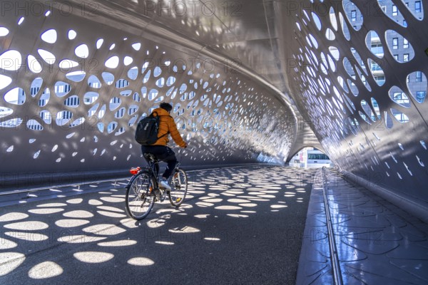Light effects from the sun in the Parkbruk, a cycle and pedestrian bridge in the city centre of Antwerp, spanning a multi-lane city centre road with tram lines, and thus connecting two lively city districts Kop Spoor Noord and Eilandje, Belgium, without any crossings, Europe