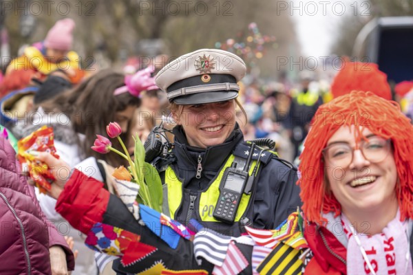 Rose Monday parade in Düsseldorf, policemen on duty at the street carnival, with flower decorations, given by the parade participants, North Rhine-Westphalia, Germany, Europe