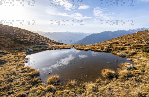 Small mountain lake on the Krahberg, sun star in the morning, mountain panorama in autumn, Venet crossing, Ötztal Alps, Tyrol, Austria, Europe