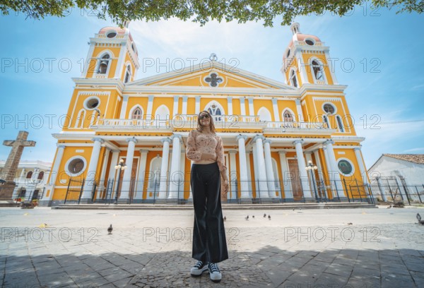 Portrait of a beautiful tourist girl in front of the cathedral in Granada, Nicaragua. Portrait of happy girl in front of a cathedral in a tourist square