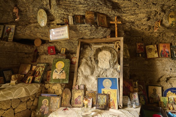 Altar area in a rock cave, surrounded by various crosses and religious symbols and icons, rock church of Agios Nikolaos, Oasis Beach, Kallithea, Rhodes, Dodecanese, Greek Islands, Greece, Europe