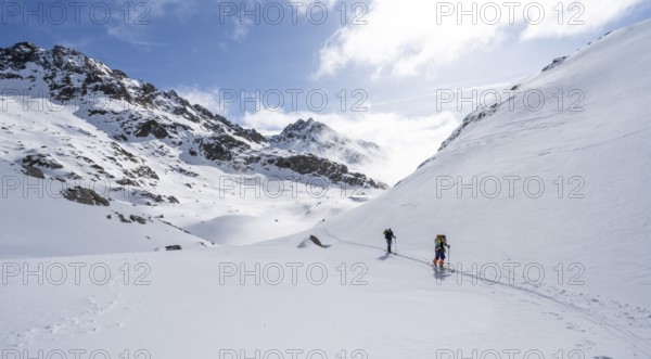 Atmospheric clouds in a wintry mountain landscape, ski tourers on the ascent to Porta d'Es-cha, Grisons Haute Route ski tour, Albula Alps, Rhaetian Alps, Grisons, Eastern Switzerland, Switzerland, Europe
