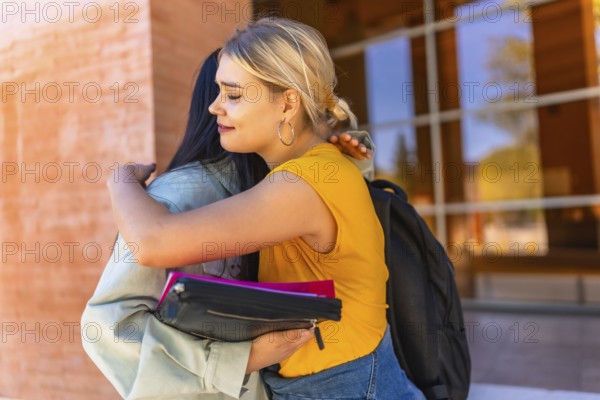 Multi-ethnic chinses and caucasian young women embracing at the entrance of the university