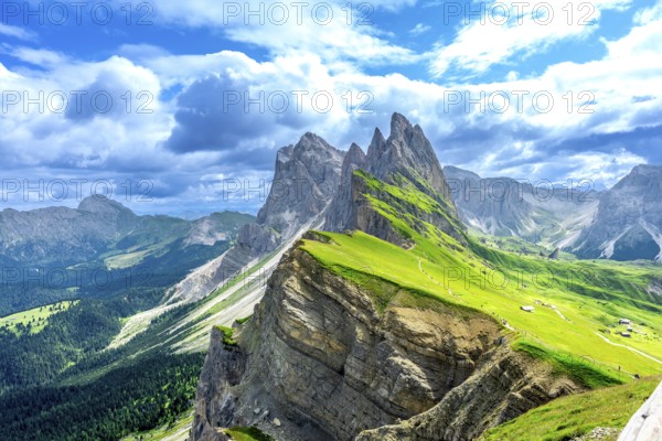 Hiking trails wind through lush green valleys beneath the majestic peaks of the seceda mountains in the italian dolomites on a sunny summer day