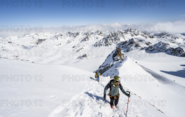 Two mountaineers with ice axe and crampons, ascent through steep snowfield to Piz Kesch or Piz d'Es-cha in winter, view of mountain panorama with glacier Vadret da Porchabella, Albula Alps, Rhaetian Alps, Grisons, Eastern Switzerland, Switzerland, Europe