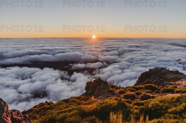 View over a sea of clouds at sunrise from a mountain peak with a calm and charming atmosphere, Pico Ruivo, Madeira, Portugal, Europe