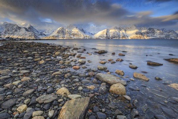 Stones, coast, snow-covered mountains, fjord, morning light, clouds, snow, Lyngen Alps, Norway, Europe