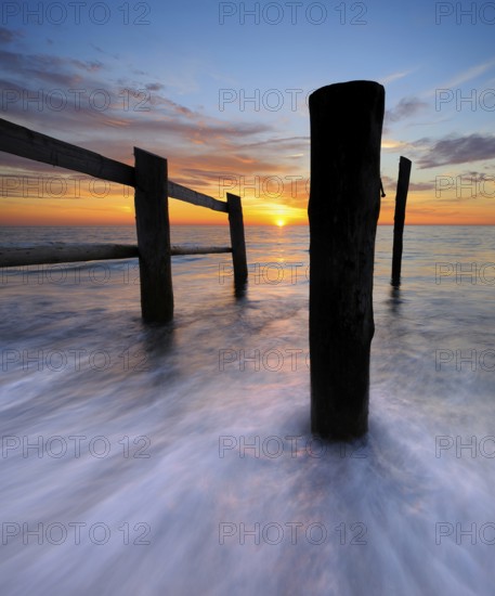 Sunset on the beach at Darßer Ort, fence and posts on the Baltic Sea as the border of the cordoned-off core zone of the Vorpommersche Boddenlandschaft National Park, Weststrand, Darß peninsula, Fischland-Darß-Zingst, Mecklenburg-Western Pomerania, Germany, Europe