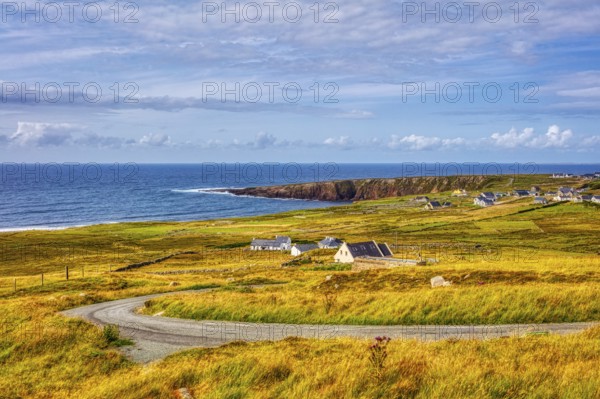 Panoramic view of a picturesque coastal landscape with cliffs, green grass and calm sea under a cloudy sky, Northern Ireland