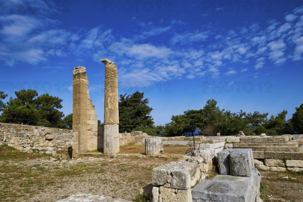 Two ancient columns amidst ruins and stone walls under a clear blue sky, Temple of Apollo, Kamiros, Archaeological site, Ancient city, Foundation of Doric Greeks, Rhodes, Dodecanese, Greek Islands, Greece, Europe