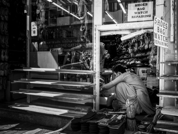 Black and white photography, shoe shops and craftsmen in Al Fahidi neighbourhood, Dubai, United Arab Emirates, Asia