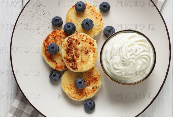 Cottage cheese pancakes, with blueberries, breakfast, on a white wooden table, no people, top view