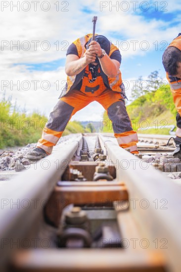 Two construction workers working on the rails, looking along the tracks in a rural setting, rail welding, track construction Hermann Hessebahn, Calw, Black Forest, Germany, Europe