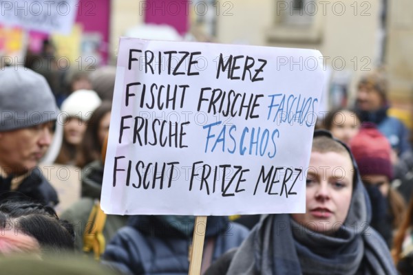 Heidelberg, Germany - February 12th 2025: Person holding up sign about CDU politian Merz and fascism in crowd at protest against far-right