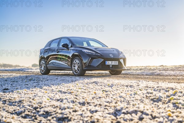 Black car on slightly icy ground under a bright morning sky, Deer E- Carsharing vehicle MG4, Calw district, Germany, Europe