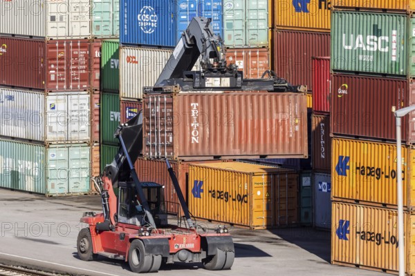 The port of Mannheim is one of Europe's most important inland ports and container terminals. Sea containers are stacked under gantry cranes waiting to be loaded onto lorries and goods trains. Mannheim, Baden-Württemberg, Germany, Europe