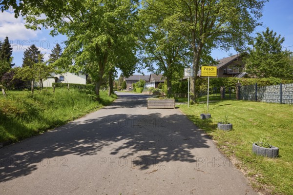 Entrance to the village with road and village sign for the district of Pesch, Nettersheim, Eifel, Euskirchen district, North Rhine-Westphalia, Germany, Europe