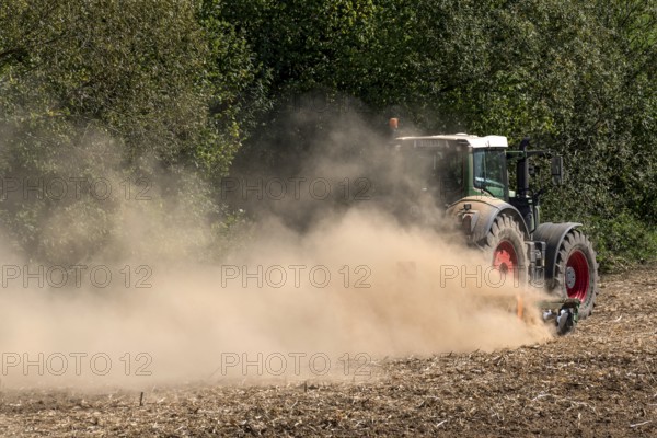 Tractor with plough digging up dried-out soil, large cloud of dust, dust, dry, field, earth, ploughing, digging up, Schwickartshausen, Nidda, Wetterau, Hesse, Germany, Europe