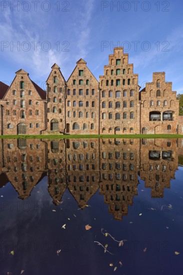 Historic salt warehouses, brick buildings reflected on the water surface of the Trave, blue sky with veil clouds, Hanseatic city of Lübeck, independent city, Schleswig-Holstein, Germany, Europe