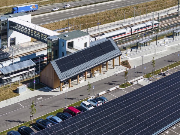Deutsche Bahn AG ICE train passing through Merklingen Swabian Alb station on the new Stuttgart to Ulm line. E-cars are charged under the solar roof at the Alb railway station. 260 solar carports can be found under the two 160 and 190 metre long roofs, drone photo, Merklingen, Baden-Württemberg, Germany, Europe