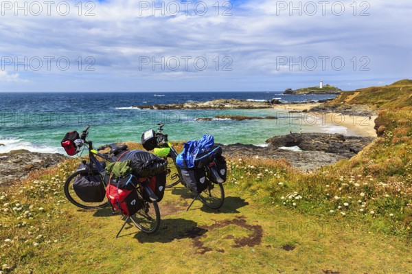 Two e-bikes on the South West Coast Path, coastline with Godrevy Island and lighthouse, landscape conservation area, National Trust, Gwithian, St Ives Bay, Cornwall, England, United Kingdom, Europe