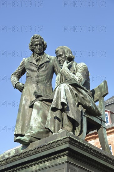 Brothers Grimm national monument, standing Jacob and sitting on the chair Wilhelm, brothers, bronze sculpture, poet, two, book, reading, free-standing, German Fairy Tale Route, market place, Hanau, Hesse, Germany, Europe