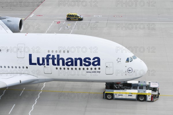 Lufthansa Airbus A380-800 being towed with push back truck on taxiway towards Lufthansa maintenance hangar, Munich Airport, Upper Bavaria, Bavaria, Germany, Europe