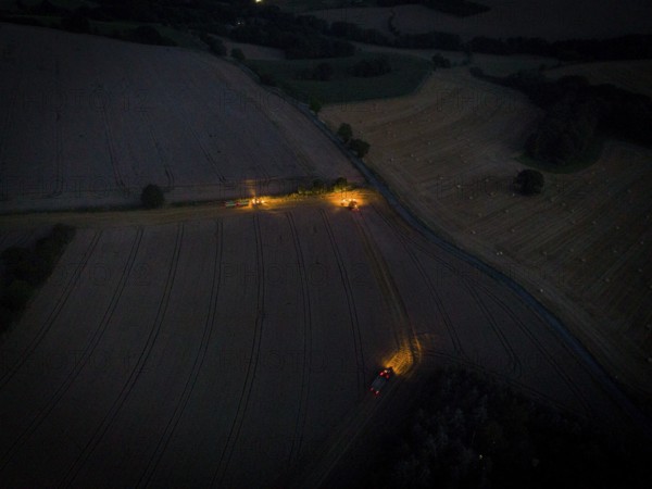 A combine harvester harvests a grain forest. When it is harvest time, the grain must also be brought from the stalk at night
