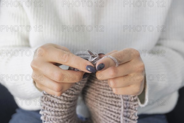 Woman home knitting close up