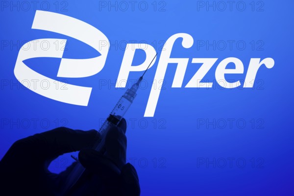 A gloved hand holding a syringe in front of the pfizer logo. Pfizer Inc. is an American multinational pharmaceutical and biotechnology corporation company