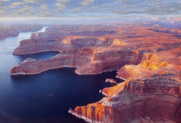 Landscape under the wing of an airplane. U.S. The coast of Lake Powell is cut by narrow canyons. Grandiose huge lake of artificial origin among the picturesque red sandstone cliffs