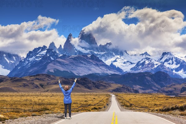Woman delighted natural beauty raised her hands. The highway leads to the snow-capped peaks of Mount Fitzroy
