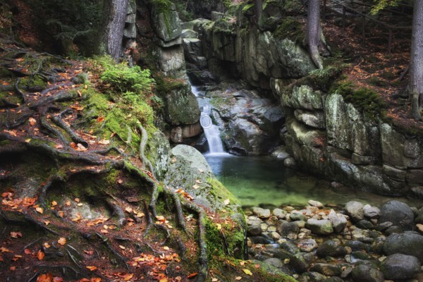 Enchanted place by the waterfall in autumn mountain forest of Karkonosze Mountains, Sudetes, Poland, Europe