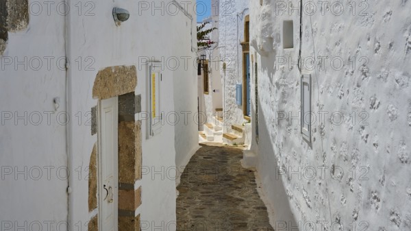 Narrow, stony corridor between white-painted houses with shutters, bright daylight, Chora, Old Town, Patmos, Dodecanese, Greek Islands, Greece, Europe