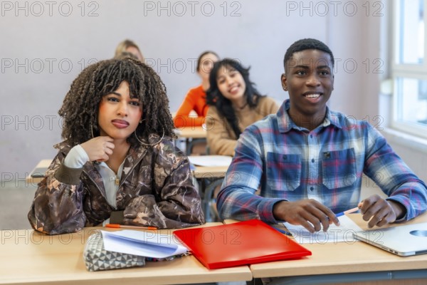 Multi ethnic students sitting at desks in a classroom, engaging with the teacher and absorbing knowledge during an interactive lesson