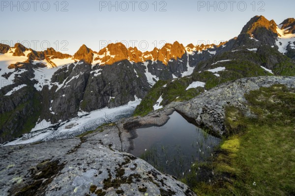 Rocky mountain peaks, small pond with cotton grass in moor landscape at Trollfjord Hytta, mountain landscape with alpenglow at sunrise, at Trollfjord, Lofoten and Vesterålen, Nordland, Norway, Europe