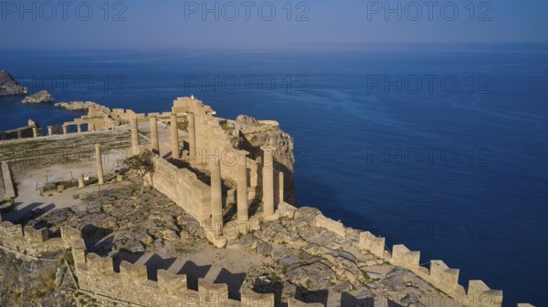 Drone shot, Acropolis of Lindos, late afternoon light, Temple of Athena Lindia, Ruins of an ancient fortress on a rocky cliff with distant sea view, Archaeological site, Lindos, Rhodes, Dodecanese, Greek Islands, Greece, Europe