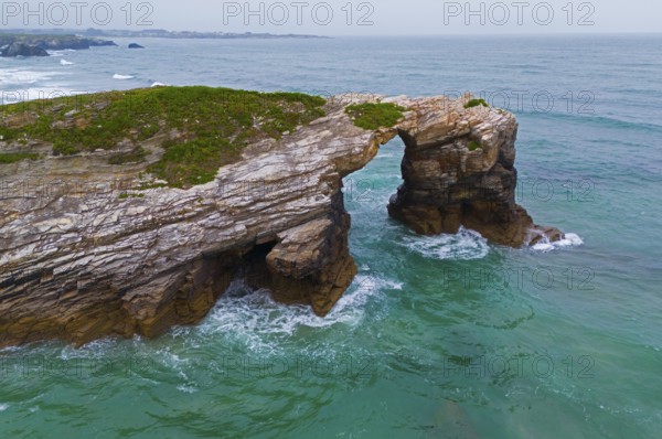 Rocky arch on the coast above the roaring ocean with green-blue water, aerial view, Praia das Catedrais, Playa de las Catedrales, Beach of the Cathedral, As Catedrais beach, Cantabrian Sea, Ribadeo, Galicia, Galicia, Spain, Europe