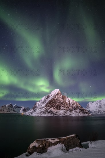 Green northern lights reflected in fjord, steep mountains, aurora borealis, winter, Reine, Moskenesoya, Lofoten, Norway, Europe