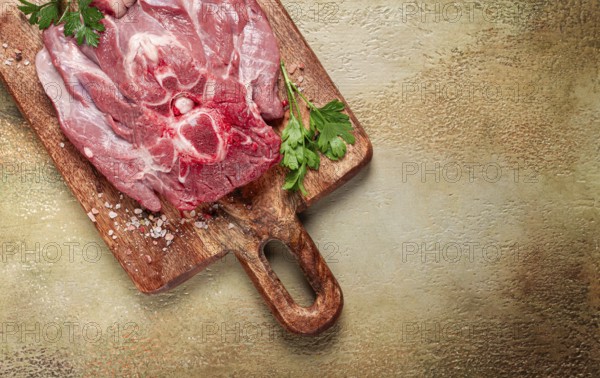 Raw steak, veal neck on the bone, fresh meat, on a cutting board, with spices, top view, without people