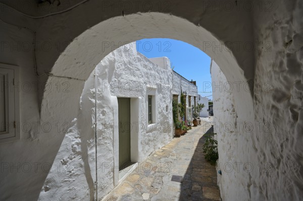 Round arch and whitewashed façade of a historic building with a cobblestone path and potted plants under a blue sky, Simantiris House, Chora, main town of Patmos, Patmos, Old Town, Dodecanese, Greek Islands, Greece, Europe