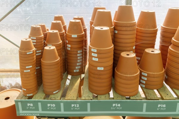 Variety of sizes of clay flower pots on display in at Swanns Nursery garden centre, Suffolk, England, UK