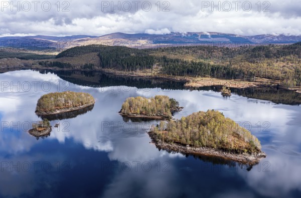 Clouds reflected in lake Loch Garry, islands on the mirrored sky, scottish highlands, aerial view, Scotland, UK