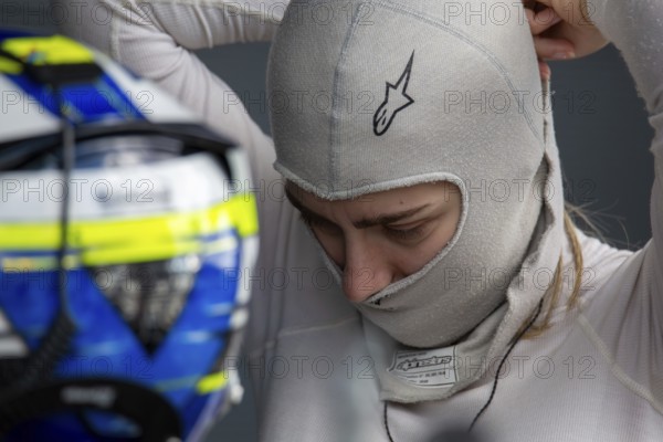 10 May 2024, Hockenheimring Germany : Spanish racing driver Alba Vazquez puts on her balavlava and gets ready to get into the cockpit (GT Open)