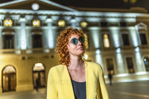 Cool female caucasian tourist walking along the city at night alone