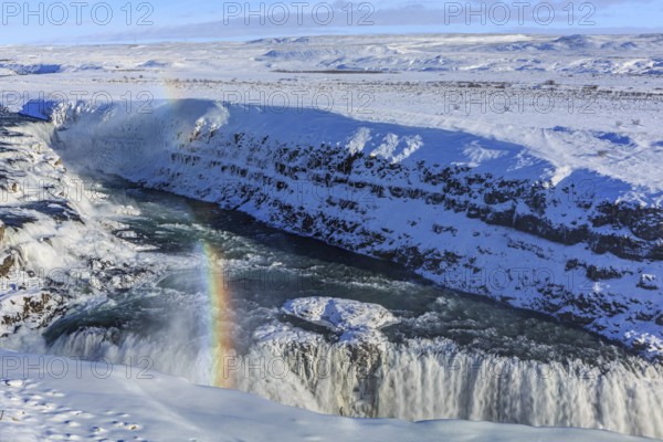 Large waterfall in a gorge in the snow, winter, sunny, rainbow, spray, Gullfoss, Golden Circle, Southwest Iceland, Iceland, Europe