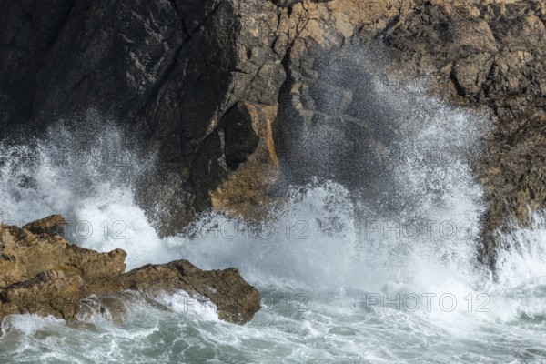 Large waves of the Atlantic Ocean crash against the rocks of a cliff. Camaret sur mer, Crozon, Finistere, Brittany, France, Europe